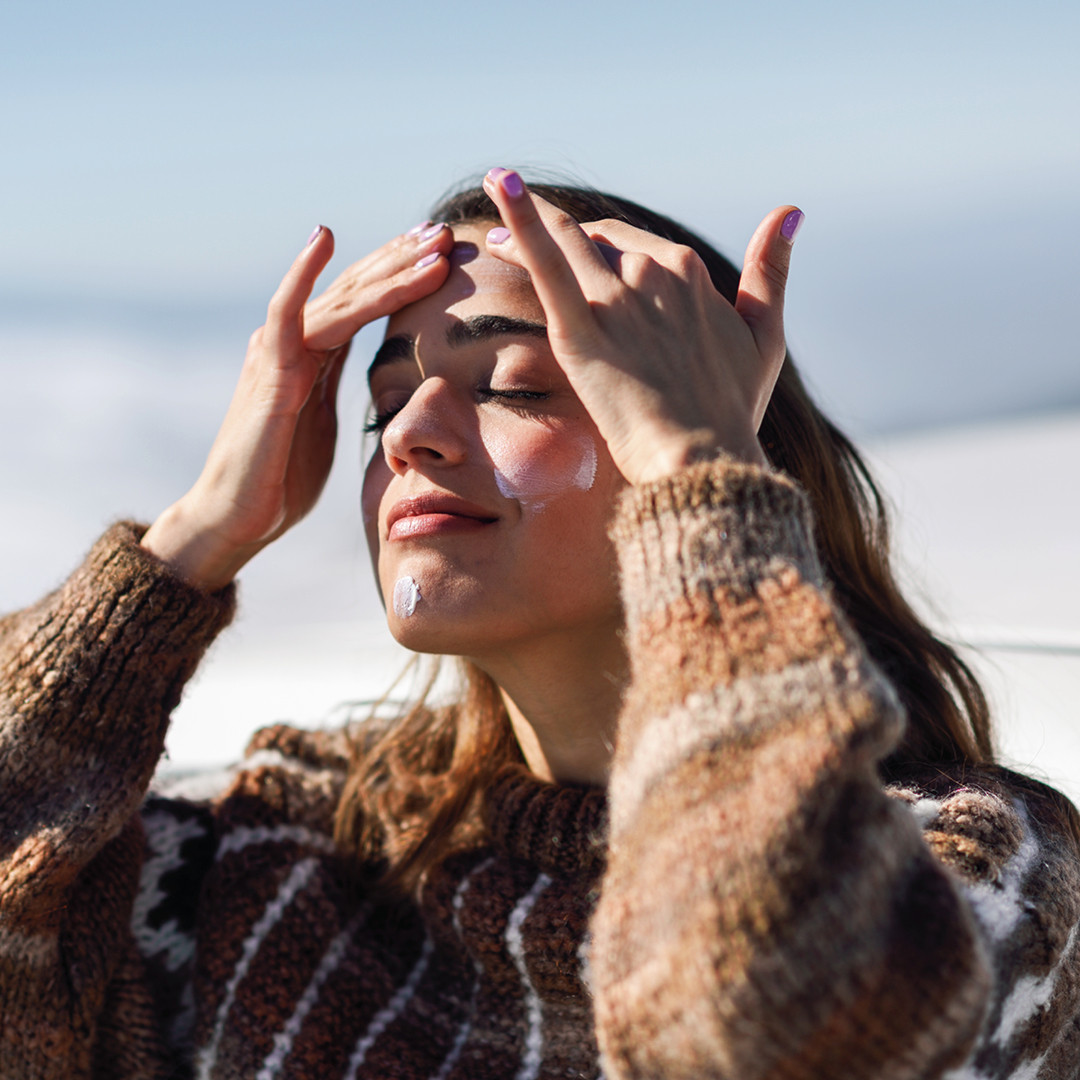 femme qui prend le soleil et met de la crème solaire